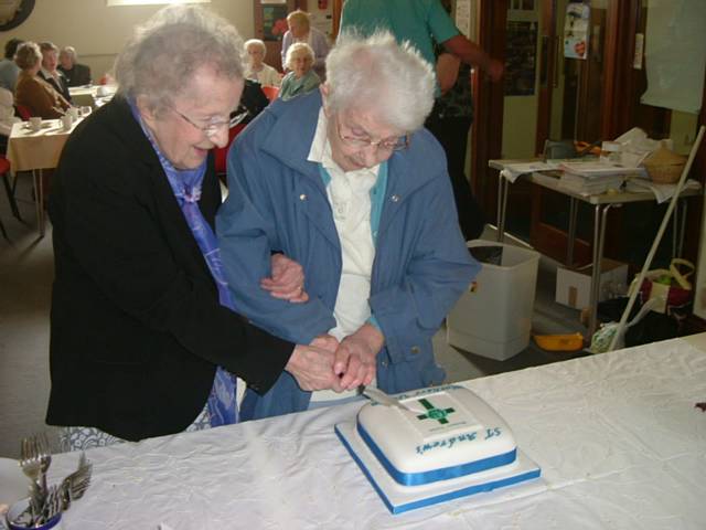 oldest and longest serving members cut the special cake